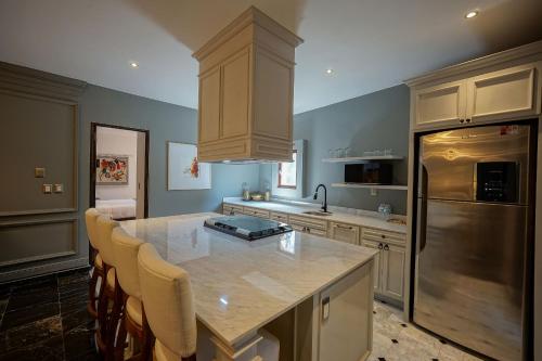 a kitchen with a kitchen island with chairs and a refrigerator at Hotel Pietro Santo in Santeagueda