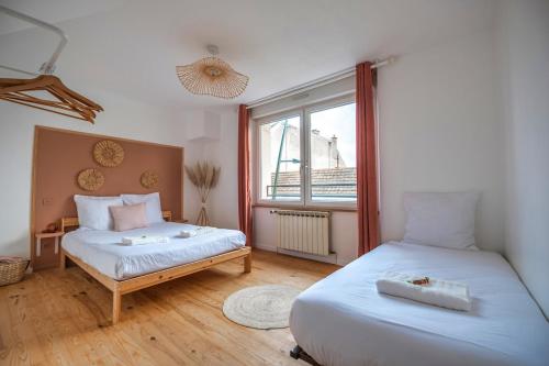 una camera da letto con due letti e una finestra di Le Loft Triplex 200M2 avec billard au centre-ville a Épernay
