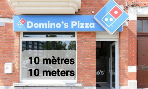 a sign for a dominos pizza in front of a building at Private Studio Brussels Airport in Brussels