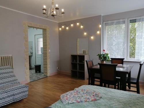 - une chambre et une salle à manger avec une table et un lit dans l'établissement Cozy and equipped outbuilding in Schiltigheim, à Schiltigheim