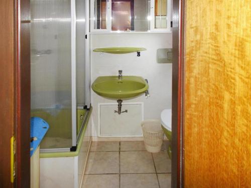 a bathroom with a green sink and a toilet at Ferienhaus, Burhave in Burhave