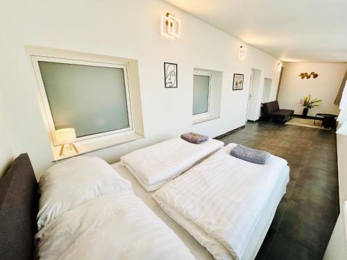 two beds in a room with two windows at Villa Apartments with Free Parking Prague 5 in Prague
