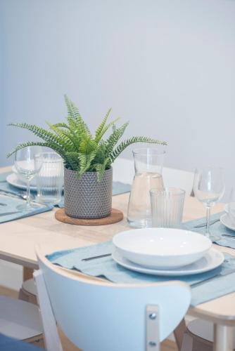 une table avec des plaques et une plante en pot dans l'établissement Appartement T5 lumineux, à Carcassonne