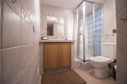 a bathroom with a toilet and a sink and a mirror at Casa Oliveira in Loulé