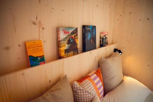 a book shelf with books on top of a couch at Exklusive Cabins am Rursee inmitten der Natur – mlab relax Eifel in Simmerath