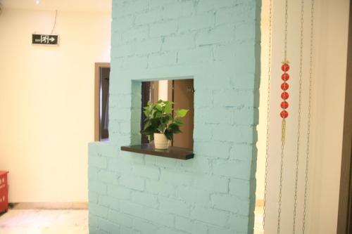 a brick wall with a mirror and a potted plant at Shanghai Fish Inn Bund in Shanghai