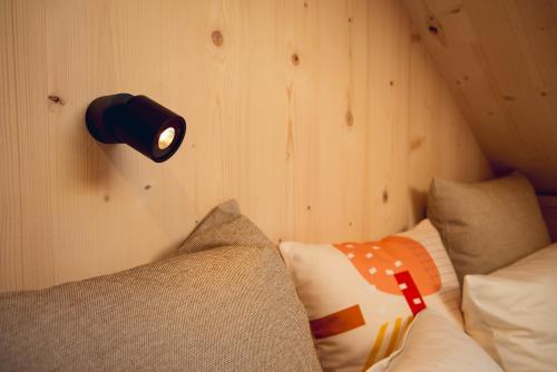 a lamp on a wall next to a bed at Exklusive Cabins am Rursee inmitten der Natur – mlab relax Eifel in Simmerath