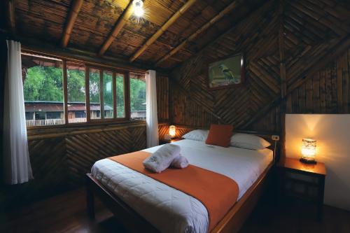 a bedroom with a bed in a room with a window at La Posada de Mindo in Mindo