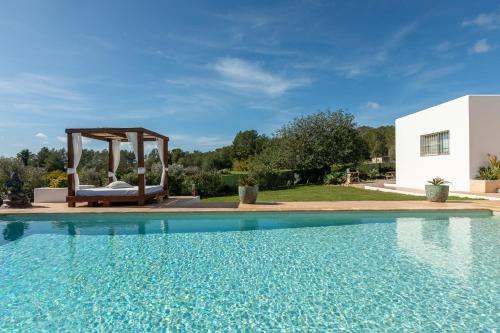 a pool with a gazebo next to a house at New! Villa Can Vinyes in San Antonio