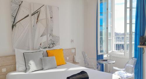 a bedroom with a bed and a large window at Hotel La Marine, Vieux Port in La Rochelle