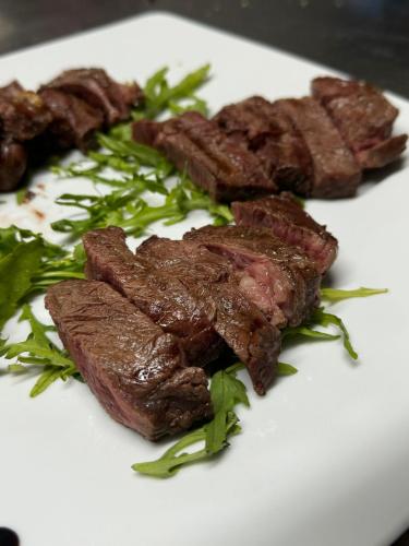 a plate of food with steak and greens on it at Agriturismo Quota 700 in Sicignano degli Alburni