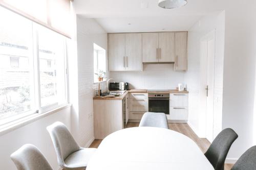 a kitchen with white cabinets and a table and chairs at Apartamento no centro da cidade in Santarém