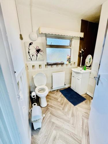 a bathroom with a toilet and a window at Birmingham 3 bedrooms- Sleeps 6- Free parking in Kidderminster