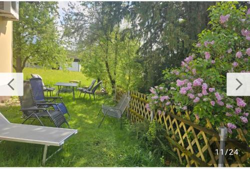 a garden with chairs and flowers and a fence at Seeparadies in Unter Feuchten