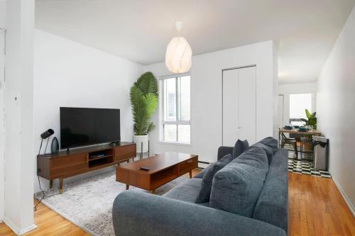 a living room with a gray couch and a tv at Bright 2BR in Plateau Mont Royal Downtown in Montréal