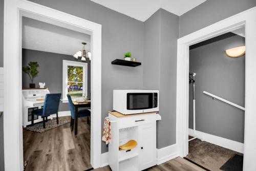 a room with a kitchen and a dining room with a microwave at A-Frame Charmer in Town, Newly Renovated in LaPorte