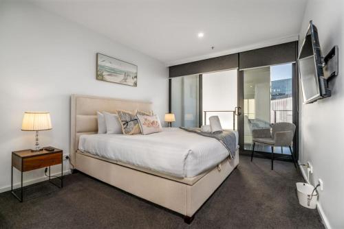 a bedroom with a bed and a table and a chair at Modern 2BR APT in Highgate Executive Apartment - Hosted by Canstay in Canberra