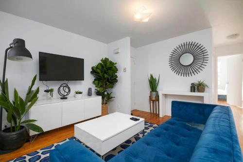 a living room with a blue couch and a tv at Stunning 2B in Plateau Mont-Royal in Montréal