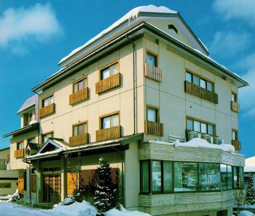 a building with snow on top of it at Berg Marukaneya in Nozawa Onsen