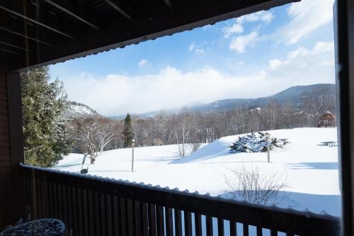 a view of a snow covered yard from a balcony at White Mountains Getaway with amazing views! in Bartlett