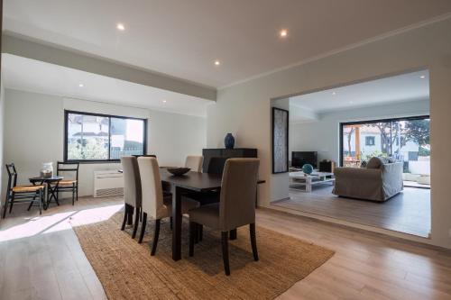 a dining room and living room with a table and chairs at BeGuest Sun & Pool House in Parede