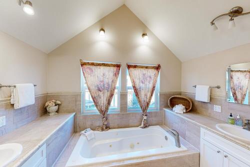 a bathroom with a large tub and two sinks at Crystal Rose Home in Lincoln City