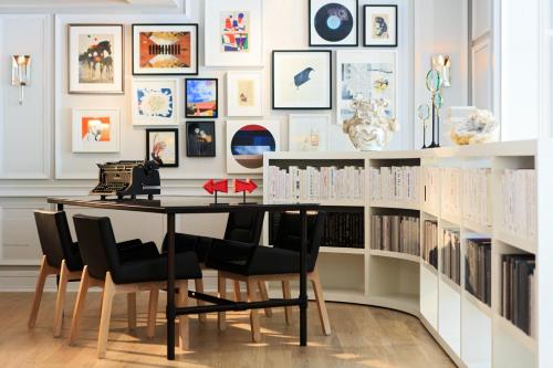 a dining room with a table and chairs and bookshelves at Kimpton Brice Hotel by IHG in Savannah