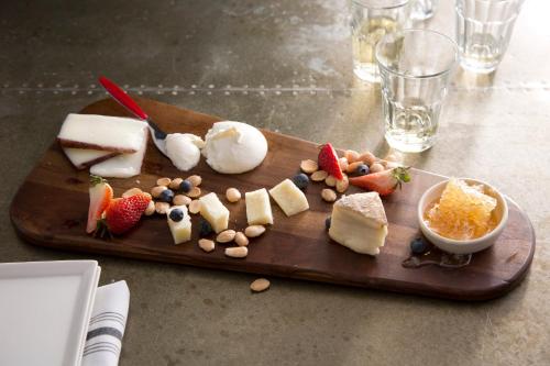 a cutting board with cheese and fruit on a table at Kimpton Brice Hotel by IHG in Savannah