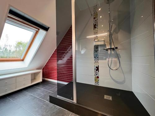 La salle de bains est pourvue d'une douche à l'italienne à côté d'une fenêtre. dans l'établissement Belle villa bord de mer avec piscine, à Urville-Nacqueville