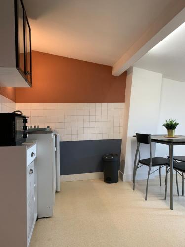 - une cuisine avec une table, une table et des chaises dans l'établissement Appartement charmant face au haras, à Saint Lo