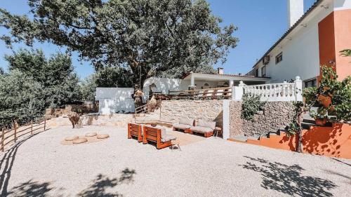 a patio with two benches and a building at Casa Angelino in Lagarteira