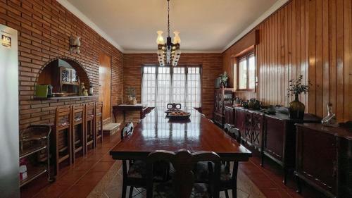 a kitchen with a table and a brick wall at Casa Angelino in Lagarteira