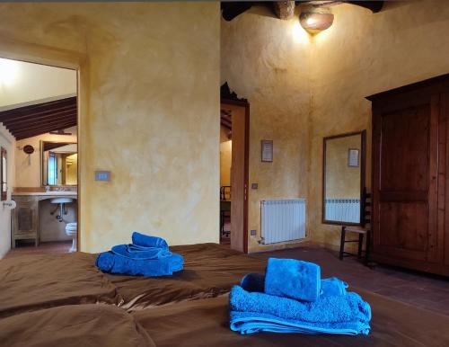 two blue towels sitting on top of a bed at Podere Rinascidentro in Asciano