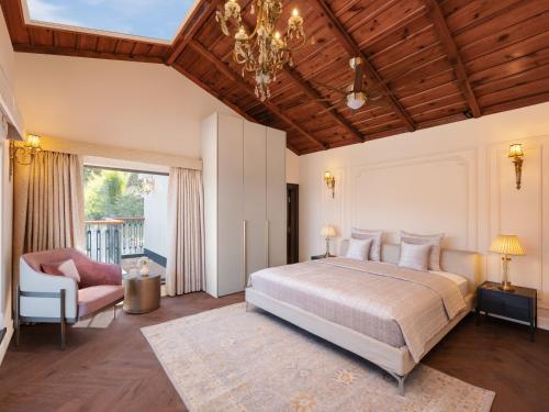 a bedroom with a large bed and a chandelier at Amaraya by LaRiSa, Nainital in Rāmgarh