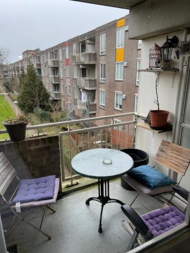 a patio with a table and chairs on a balcony at B&B Calypso Amsterdam Shared Apartment in Amsterdam
