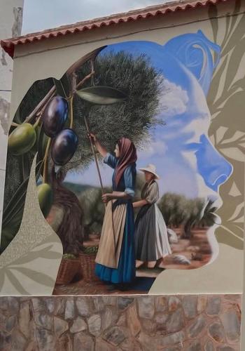 a painting of two people on the side of a wall at El suéño de Fondón in Fondón