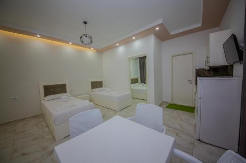 a white room with white tables and white chairs at Hotel Landi in Ksamil