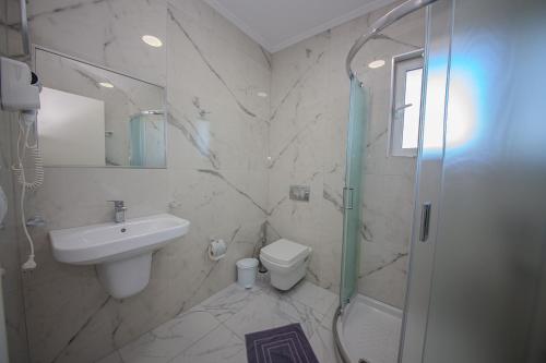 a bathroom with a sink toilet and a shower at Hotel Landi in Ksamil
