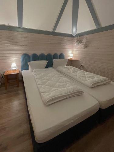 a large white bed in a room with two lamps at Ferienhaus "Schmetterling" am See im Bergland in Kirchheim