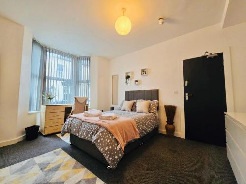 a bedroom with a bed and a desk and a window at Room 1 Shared House in L7 in Liverpool
