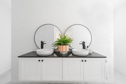 a bathroom with two sinks and two mirrors at Parkview for 8, Moss Vale, Southern Highlands in Moss Vale