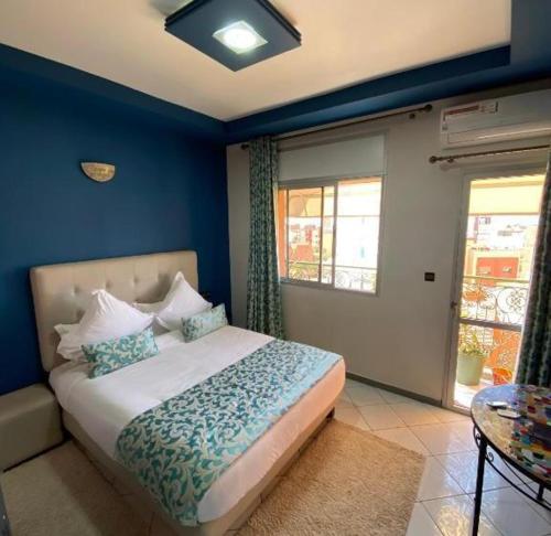 a bedroom with a large bed with blue walls at Hotel VELSATIS in Beni Mellal