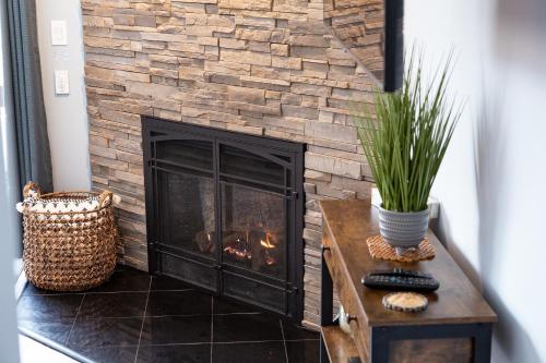 a fireplace in a living room with a brick wall at White Mountains Getaway with amazing views! in Bartlett