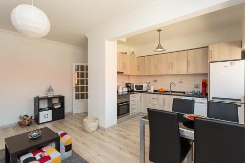 a kitchen with wooden cabinets and a white refrigerator at BeGuest Parede Beach Apartment – Cascais in Parede