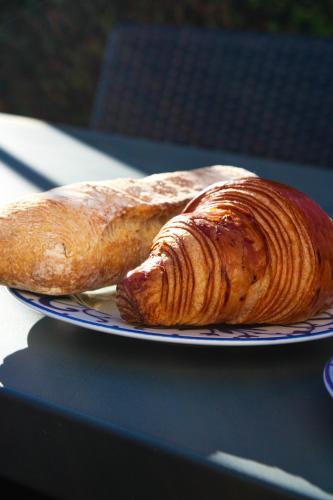 a plate with a croissant and a pastry on it at Hotel La Villa Fleurie in Beaune