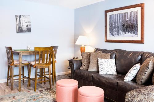 a living room with a brown leather couch and a table at White Mountains Getaway with amazing views! in Bartlett