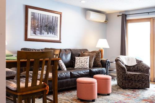a living room with a leather couch and a chair at White Mountains Getaway with amazing views! in Bartlett