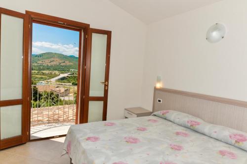 a bedroom with a bed and a sliding glass door at Residence in Malamurì near Budoni, apartments 4 beds with private outdoor area in Budoni