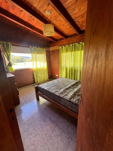 a bedroom with a bed with green curtains at Cabañas San Lorenzo in San Lorenzo