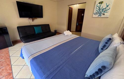 a large blue bed in a room with a television at HOTEL EL CORAL in Punta Mita